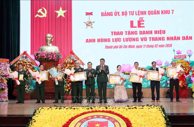 Trung tướng Lê Xuân Thế, Tư lệnh Quân khu 7; Trung tướng Trần Vinh Ngọc, Chính ủy Quân khu 7 tặng hoa chúc mừng các đồng chí nhận danh hiệu Anh hùng lực lượng vũ trang nhân dân; chúc mừng thân nhân các đồng chí được truy tặng danh hiệu Anh hùng lực lượng vũ trang nhân dân. Ảnh: Xuân Khu-TTXVN