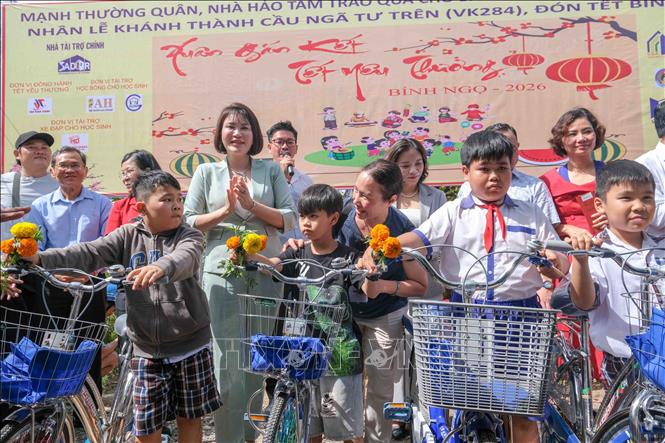 Ban tổ chức trao xe đạp cho 20 học sinh vượt khó học giỏi của xã An Lạc Thôn. Ảnh: Thanh Liêm - TTXVN