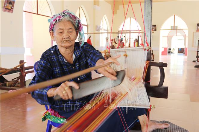 Nghệ nhân Hợp tác xã Dệt thổ cẩm Chăm Mỹ Nghiệp (xã Ninh Phước) miệt mài bên khung dệt, gìn giữ nghề truyền thống của đồng bào Chăm. Ảnh: Nguyễn Thành – TTXVN