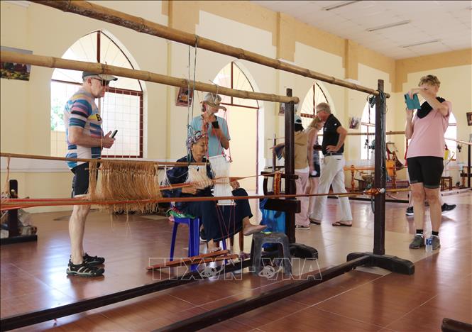 Du khách nước ngoài tham quan, tìm hiểu quy trình dệt thổ cẩm tại Hợp tác xã Dệt thổ cẩm Chăm Mỹ Nghiệp (xã Ninh Phước). Ảnh: Nguyễn Thành – TTXVN