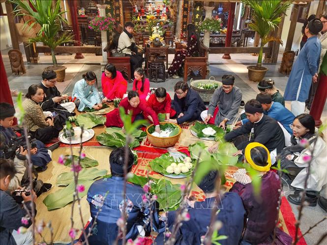 Giữa lòng phố cổ, cùng gói bánh chưng đón Tết như cách của người Hà Nội xưa. Ảnh: Thanh Tùng – TTXVN