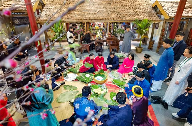 Giữa lòng phố cổ, cùng gói bánh chưng đón Tết như cách của người Hà Nội xưa. Ảnh: Thanh Tùng – TTXVN