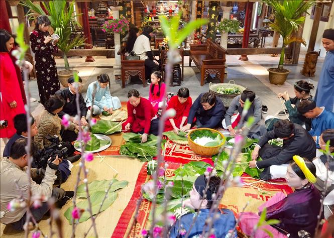 Giữa lòng phố cổ, cùng gói bánh chưng đón Tết như cách của người Hà Nội xưa. Ảnh: Thanh Tùng – TTXVN