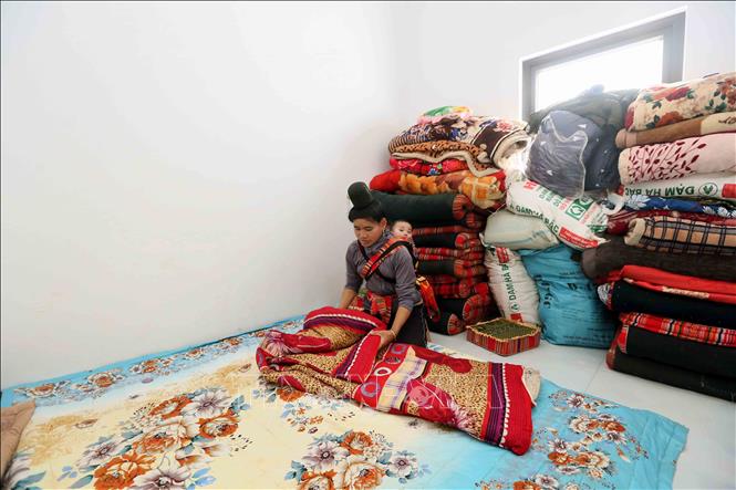 Chị Lò Thị Thơi, bản Nậm Pù, xã Huổi Một, tỉnh Sơn La sắp xếp vật dụng gia đình để về ở trong căn nhà mới. Ảnh: Quang Quyết - TTXVN