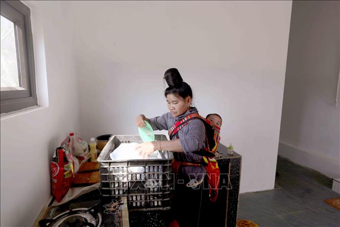 Chị Lò Thị Thơi, bản Nậm Pù, xã Huổi Một, tỉnh Sơn La sắp xếp vật dụng gia đình để về ở trong căn nhà mới. Ảnh: Quang Quyết - TTXVN
