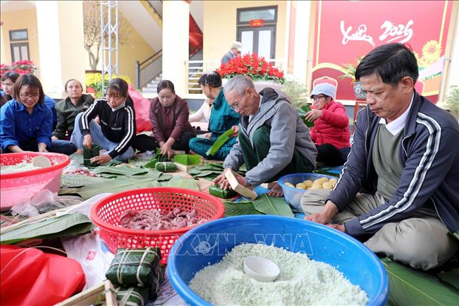 Những đôi tay thoăn thoắt gói bánh chưng, những nụ cười rạng rỡ, những câu chuyện đầu xuân râm ran đã làm cho khoảng sân thêm ấm tình làng nghĩa xóm. Ảnh: Việt Hoàng - TTXVN 