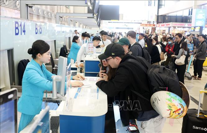 Du khách quốc tế làm thủ tục nối chuyến bay nội địa đến thành phố biển Đà Nẵng đón Tết cổ truyền Việt Nam, sáng 13/2 (26 tháng Chạp). Ảnh: Quốc Khánh - TTXVN