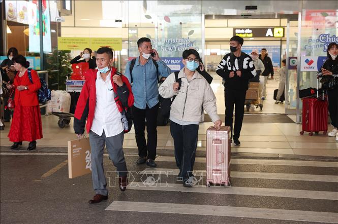 Người dân vội vã đẩy hành lý nhanh chóng rời khỏi sân bay Nội Bài sáng 13/2. Ảnh: Quốc Khánh - TTXVN