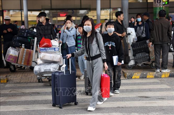 Người dân mệt mỏi rời sân bay Nội Bài, sáng 13/2. Ảnh: Quốc Khánh - TTXVN