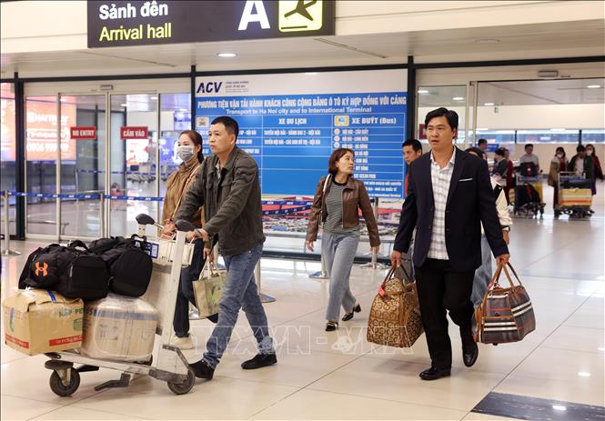 Người dân vội vã đẩy hành lý nhanh chóng rời khỏi sân bay Nội Bài sáng 13/2. Ảnh: Quốc Khánh - TTXVN