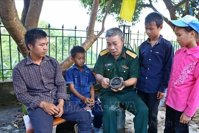 Trung tá Nguyễn Văn Minh, Trưởng Ban Công binh (Bộ Chỉ huy Quân sự Hà Giang) chia sẻ về tác hại và ảnh hưởng của bom, mìn, vật nổ với đồng bào, giúp người dân Hà Giang nâng cao ý thức phòng, tránh, đảm bảo an toàn tính mạng và tài sản, tạo điều kiện thuận lợi cho nhân dân vùng biên giới có đất canh tác. Ảnh: Minh Quyết - TTXVN
