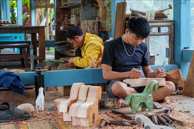 Những nghệ nhân trẻ của làng Củi lũ đã có nhiều sáng tạo trong việc phối hợp giữa các nghề mộc, đúc đồng, sơn mài để cho ra các sản phẩm thủ công mỹ nghệ độc bản hấp dẫn khách hàng. Ảnh: Xuân Quý - TTXVN