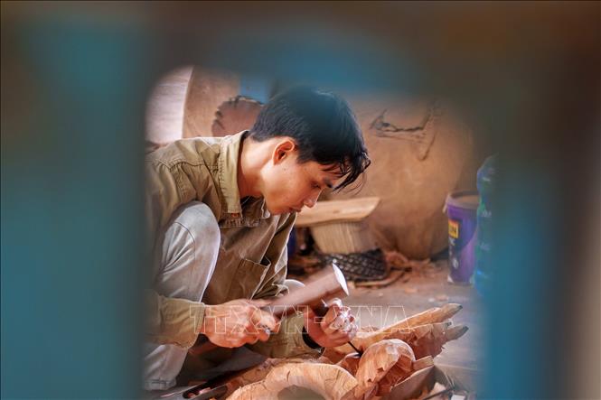 Những nghệ nhân trẻ của làng Củi lũ đã có nhiều sáng tạo trong việc phối hợp giữa các nghề mộc, đúc đồng, sơn mài để cho ra các sản phẩm thủ công mỹ nghệ độc bản hấp dẫn khách hàng. Ảnh: Xuân Quý - TTXVN 