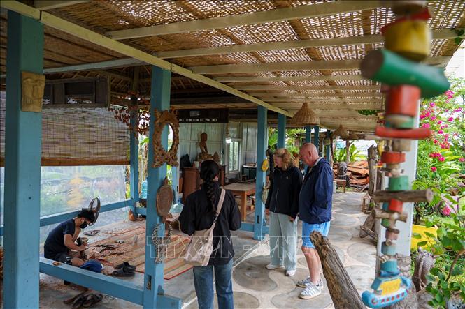 Những nghệ nhân trẻ của làng Củi lũ đã có nhiều sáng tạo trong việc phối hợp giữa các nghề mộc, đúc đồng, sơn mài để cho ra các sản phẩm thủ công mỹ nghệ độc bản hấp dẫn khách hàng. Ảnh: Xuân Quý - TTXVN 