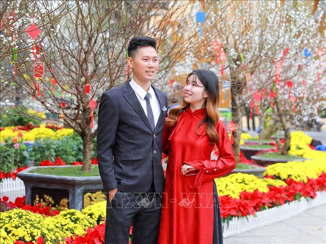 Người dân lưu lại hình ảnh sắc Xuân rực rỡ tại không gian hoa xuân tại Vườn hoa Lý Thái Tổ. Ảnh: Khánh Hoà - TTXVN