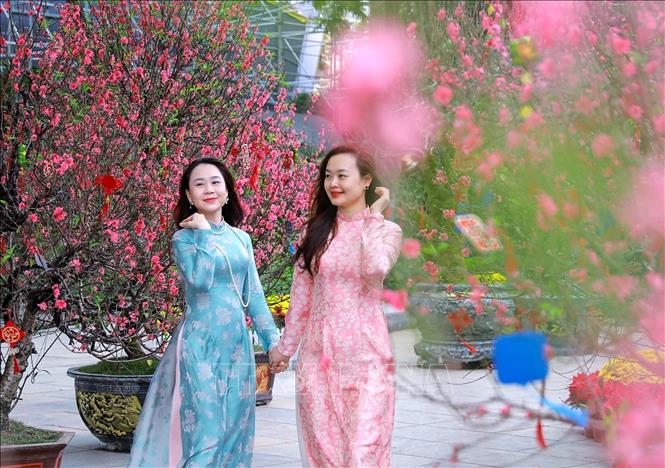 Người dân lưu lại hình ảnh sắc Xuân rực rỡ tại không gian hoa xuân tại Vườn hoa Lý Thái Tổ. Ảnh: Khánh Hoà - TTXVN