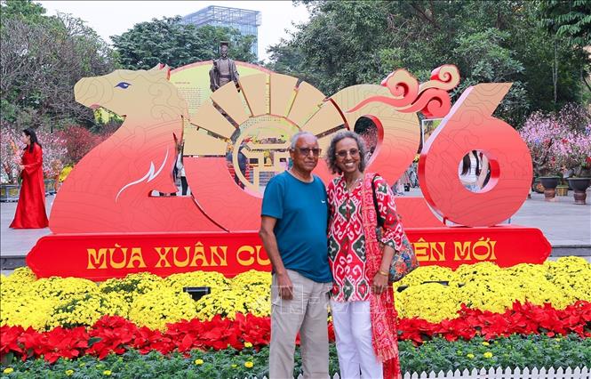 Du khách lưu lại hình ảnh sắc Xuân rực rỡ tại không gian hoa xuân tại Vườn hoa Lý Thái Tổ. Ảnh: Khánh Hoà - TTXVN