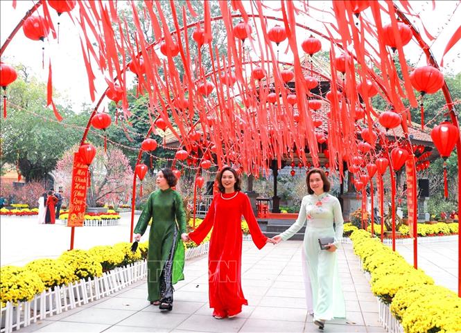 Người dân lưu lại hình ảnh sắc Xuân rực rỡ tại không gian hoa xuân tại Vườn hoa Lý Thái Tổ. Ảnh: Khánh Hoà - TTXVN