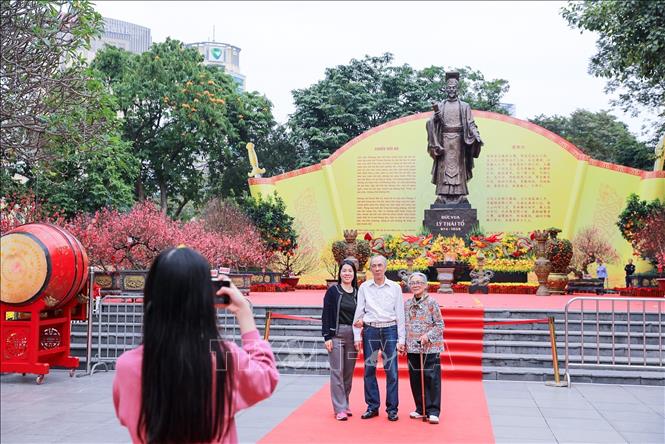 Người dân lưu lại hình ảnh sắc Xuân rực rỡ tại không gian hoa xuân tại Vườn hoa Lý Thái Tổ. Ảnh: Khánh Hoà - TTXVN