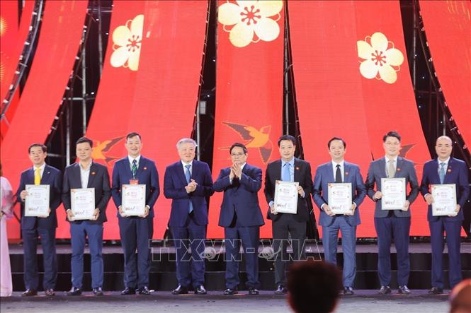 Thủ tướng Phạm Minh Chính trao giấy chứng nhận vinh danh các đơn vị tiêu biểu góp phần thành công của Hội chợ Mùa Xuân lần thứ nhất năm 2026. Ảnh: Dương Giang-TTXVN

