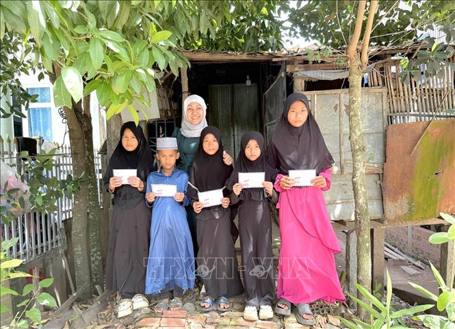 Bà Sity Hara, Phó Ban Từ thiện xã hội, Ban đại diện cộng đồng Hồi giáo tỉnh An Giang trao quà đến bà con đồng bào Chăm có hoàn cảnh khó khăn trên địa bàn nhân Tháng ăn chay Ramadan. Ảnh: Công Mạo-TTXVN