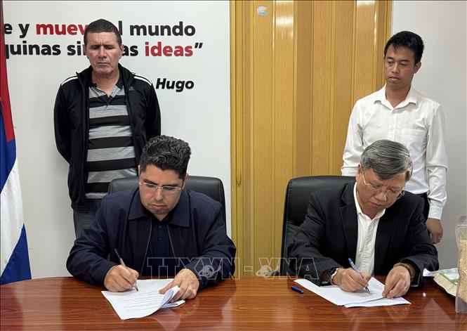 Đại sứ Việt Nam tại Cuba Lê Quang Long, và Thứ trưởng Bộ Nông Nghiệp Cuba Telce Abdel González ký biên bản giao nhận gạo. Ảnh: Việt Hùng-P/v TTXVN tại Cuba