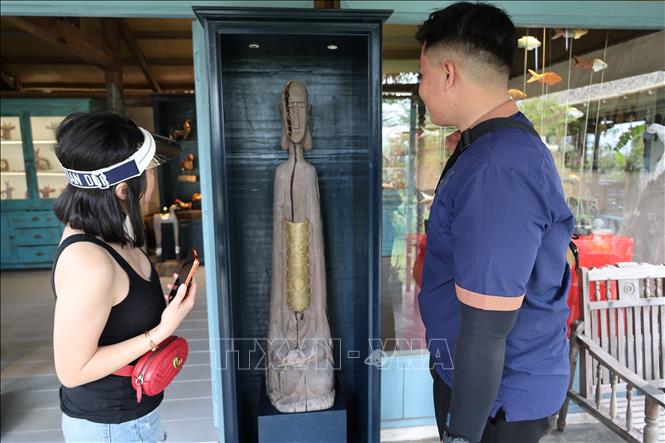 Du khách bất ngờ bởi sự sáng tạo của các nghệ nhân trẻ tại làng Củi lũ khi kết hợp giữa nhiều loại vật liệu khác nhau, tạo nên tác phẩm nghệ thuật hoàn toàn giữ được nét thô mộc của vật liệu củi lũ. Ảnh: Xuân Quý - TTXVN