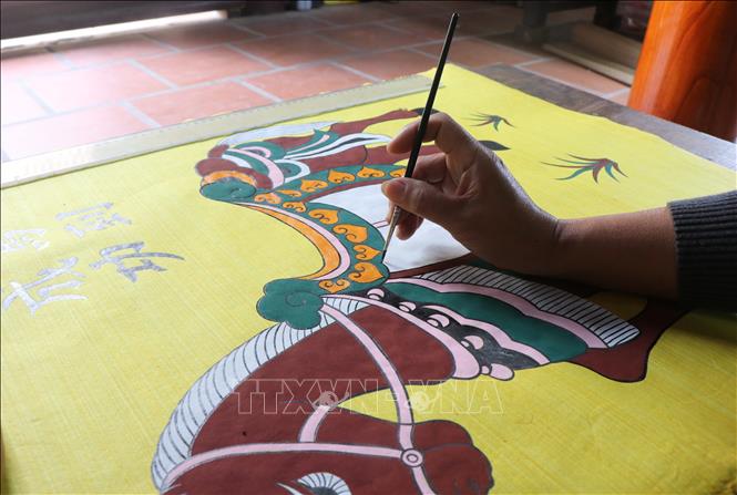 An artisan in Dong Ho village creates folk paintings with the theme of horses for Tet (Lunar New Year). VNA Photo: Thanh Thương