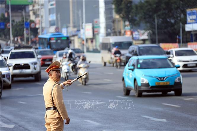 Lực lượng CSGT phân luồng các phương tiện lối xuống cầu Vĩnh Tuy đi Long Biên. Ảnh: Tuấn Anh - TTXVN