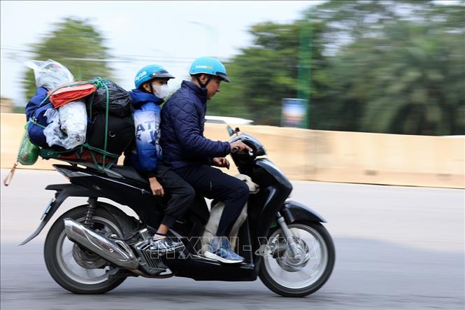 Hai bố con với đồ đạc lỉnh kỉnh chất đầy trên xe vội vã rời Hà Nội. Ảnh: Tuấn Anh - TTXVN