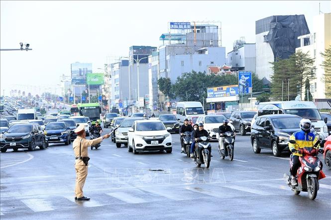 Lực lượng CSGT phân luồng các phương tiện lối xuống cầu Vĩnh Tuy đi Long Biên. Ảnh: Tuấn Anh - TTXVN