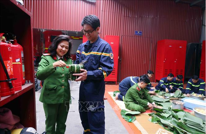 Tết đến với lính cứu hỏa không chỉ có tiếng còi báo động mà còn có cả những phút giây sẻ chia tình đồng chí, đồng đội. Sự góp mặt của các bóng hồng khiến không khí ấm áp hơn. Ảnh: Phạm Kiên - TTXVN

