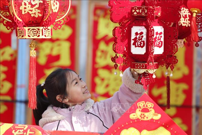 Em nhỏ chọn mua đồ trang trí Tết tại tỉnh Sơn Đông, Trung Quốc. Ảnh: THX/TTXVN