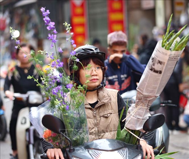 Người dân đi chợ truyền thống, chợ dân sinh mua hoa về đón Tết. Ảnh: Thanh Tùng - TTXVN
