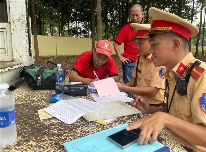Lực lượng chức năng lập biên bản xe khách nhồi nhét khách. Ảnh: Đậu Tất Thành – TTXVN.