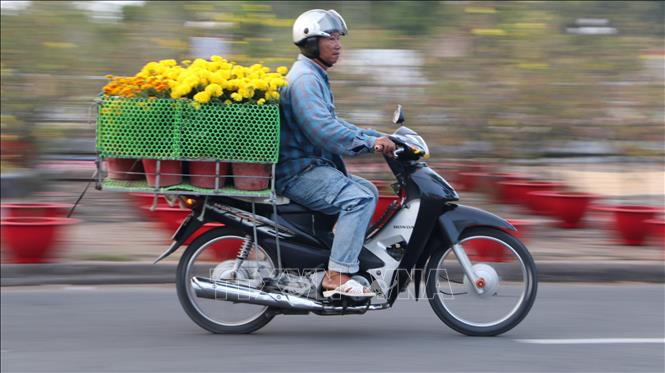 Tiểu thương chuẩn bị chuyển hoa đến khách hàng. Ảnh: Hồng Thái - TTXVN