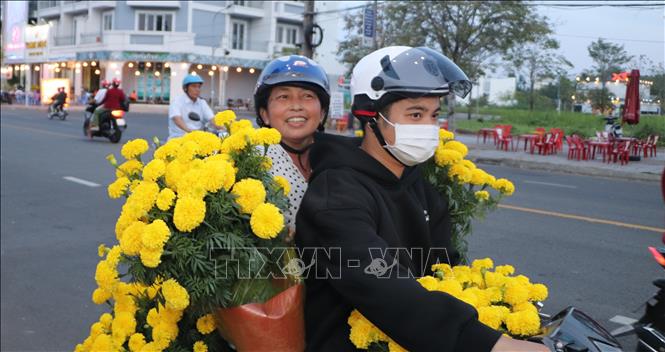 Người dân lựa chọn các loại hoa trang trí Tết. Ảnh: Hồng Thái - TTXVN