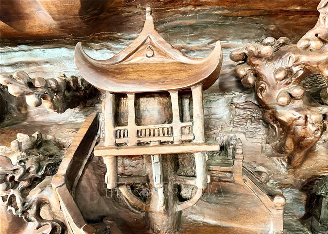 Hình ảnh Chùa Một Cột được chạm khắc tinh xảo trên bức tranh gỗ lũa, tái hiện nét văn hóa đặc trưng miền Bắc. Ảnh: Thanh Sang-TTXVN