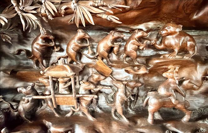 Đám cưới chuột là một trong những bức tranh dân gian Đông Hồ nổi tiếng nhất Việt Nam được tái hiện trên thân gỗ lũa. Ảnh: Thanh Sang-TTXVN