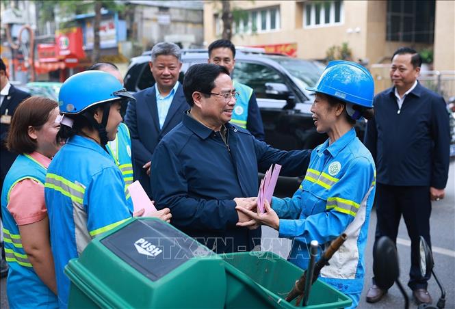 Thủ tướng Phạm Minh Chính thăm, chúc Tết công nhân đang thu gom, vận chuyển, xử lý rác thải khu vực Yên Thế - Nguyễn Thái Học. Ảnh: Dương Giang-TTXVN 
