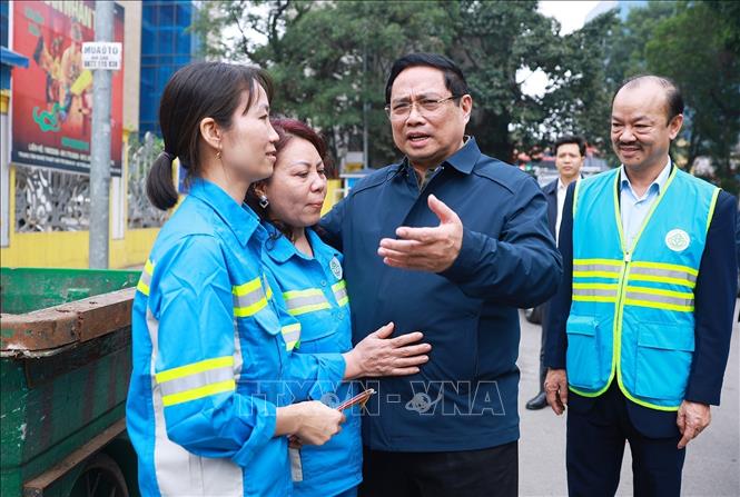 Thủ tướng Phạm Minh Chính thăm, chúc Tết công nhân đang thu gom, vận chuyển, xử lý rác thải khu vực đường Trần Nhân Tông. Ảnh: Dương Giang-TTXVN
