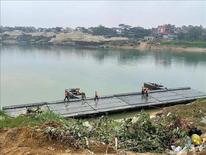 Lực lượng quân đội khẩn trương lắp đặt cầu phao tạm qua sông Lô. Ảnh: Nguyễn Văn Cảnh - TTXVN
