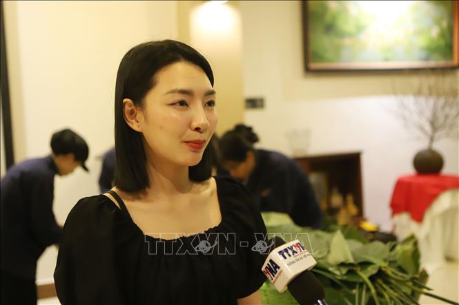 Cô Vannydeuane Souvanmani, con dâu chị Phạm Thu Hương, chia sẻ cảm nhận khi được tự tay gói bánh chưng Tết. Ảnh: Xuân Tú - PV TTXVN tại Lào