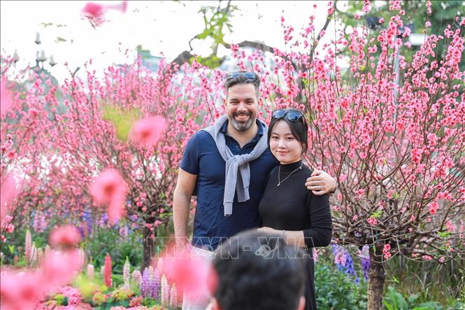 Sắc Xuân rực rỡ tại khu vực xung quanh Hồ Hoàn Kiếm thu hút sự quan tâm của du khách. Ảnh: Khánh Hoà - TTXVN