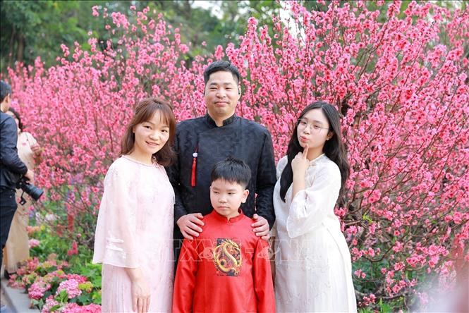 Người dân chụp ảnh lưu lại khoảnh khắc Xuân rực rỡ tại khu vực xung quanh Hồ Hoàn Kiếm. Ảnh: Khánh Hoà - TTXVN