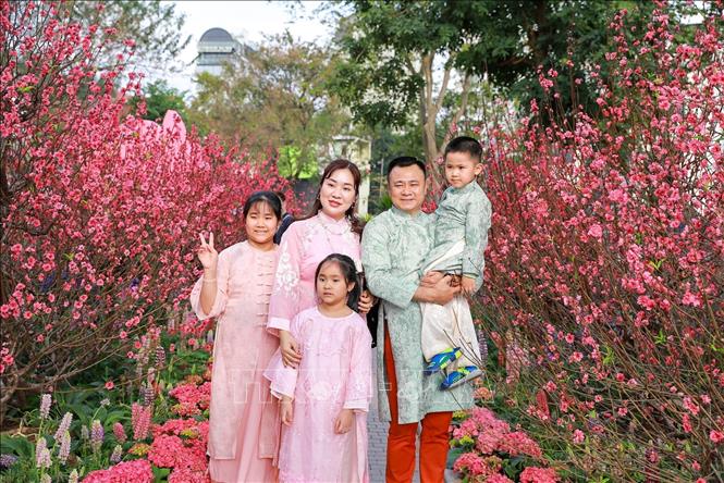 Người dân chụp ảnh lưu lại khoảnh khắc Xuân rực rỡ tại khu vực xung quanh Hồ Hoàn Kiếm. Ảnh: Khánh Hoà - TTXVN