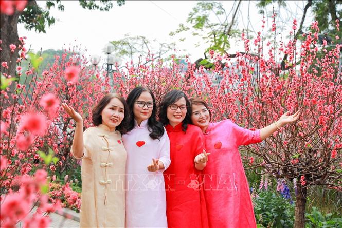 Người dân chụp ảnh lưu lại khoảnh khắc Xuân rực rỡ tại khu vực xung quanh Hồ Hoàn Kiếm. Ảnh: Khánh Hoà - TTXVN