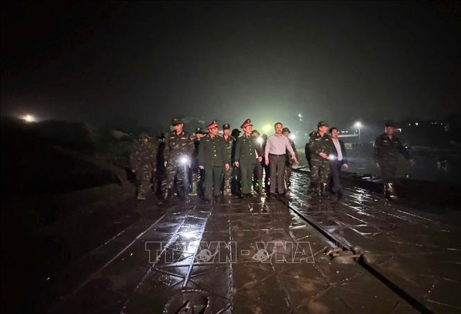 Lực lượng quân đội kiểm tra việc lắp đặt cầu phao, tối 15/2. Ảnh: Nguyễn Văn Cảnh - TTXVN
