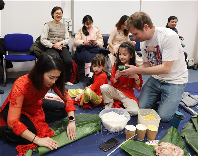 Một gia đình Việt - Anh hào hứng tham gia cuộc thi gói bánh chưng tại lễ hội. Ảnh: Phong Hà - PV TTXVN tại Anh 