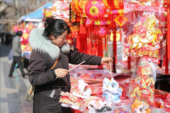 Người dân chọn mua đồ trang trí Tết tại tỉnh Cam Túc, Trung Quốc. Ảnh: THX/TTXVN